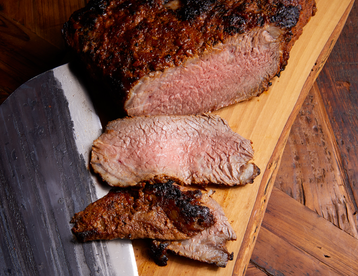 Tri Tip cut into thin slices on a wooden cutting board